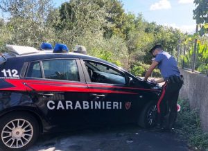 immagine di una macchina dei carabinieri e un carabiniere