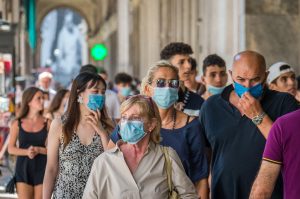 immagine di persone che sono per strada e indossano la mascherina